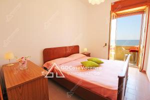 トッレ・パリにあるGDCaseVacanza - Sulla Spiaggia Maldive del Salento -のベッドルーム1室(ベッド1台、テーブル、窓付)