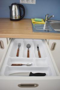 a white sink with utensils in a kitchen at YouthMents - Student Hotel in Rīga