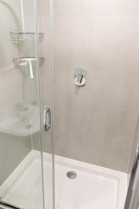 um chuveiro com uma porta de vidro numa casa de banho em YouthMents - Student Hotel em Riga