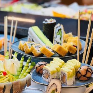 zwei Teller Sushi und andere Speisen auf einem Tisch in der Unterkunft HVD Viva Club Ultra All Inclusive & Beach Snack Bar - Free Parking in Goldstrand