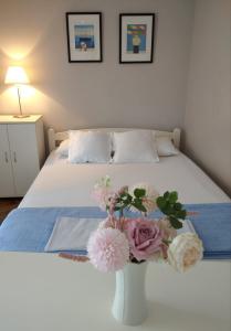 ベオグラードにあるApartment Bella Vistaの花瓶付きのベッド1台が備わるベッドルーム1室が備わります。
