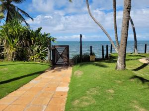 a gate to the beach with the ocean in the background at Solar dos Arcos in Praia do Forte
