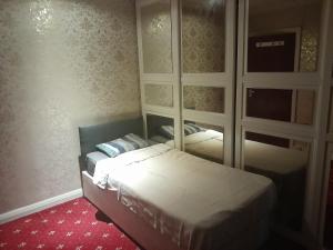 a small bedroom with a bed and a mirror at Lovely 1-Bed Studio in London in London