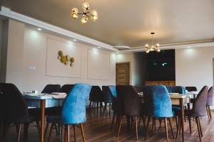 a dining room with tables and blue chairs at ALOFT in Kazbegi