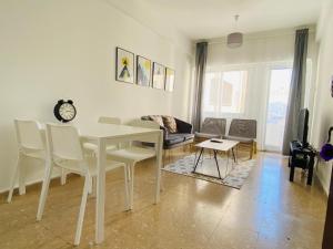 a living room with a white table and chairs at Engomi Apartment in Yukarı Lakatamya
