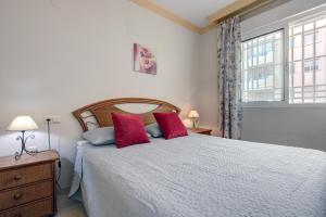 マルベーリャにあるFirst Line Beach Apartmentのベッドルーム1室(赤い枕のベッド1台、窓付) +22枚の写真