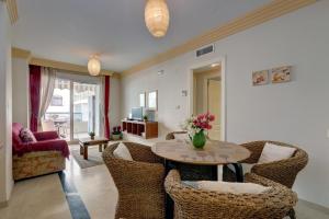 マルベーリャにあるFirst Line Beach Apartmentのテーブルと椅子のあるリビングルーム