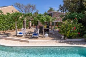 a swimming pool with chairs and a table and a house at Alcudia - 38363 Mallorca in Alcudia
