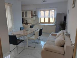 - un salon avec un canapé et une table avec des chaises dans l'établissement Apartments Bakša, à Kanfanar