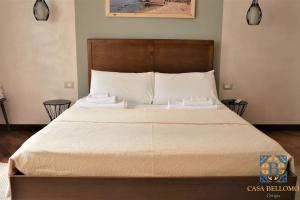 een slaapkamer met een groot bed met een houten hoofdeinde bij Casa Bellomo Ortigia in Siracusa