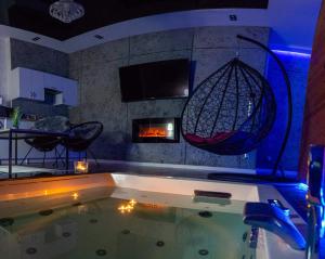 a bath tub with a fire in a room at Apartament MINUS in Mrągowo