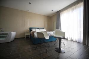 a room with a bed and a sink and a tub at Quaint Boutique Hotel Sannat in Sannat