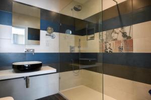 a bathroom with a glass shower and a sink at Quaint Boutique Hotel Sannat in Sannat