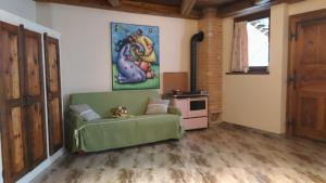 una sala de estar con un sofá verde y una pintura en A due passi da..., en Aosta