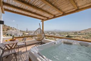 una vasca idromassaggio sul balcone di una casa di Naxos Pantheon Luxury Apartments ad Agkidia