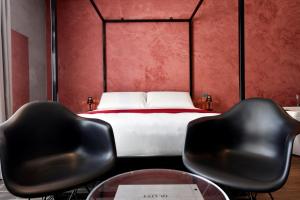 two black chairs in a bedroom with a bed at Quaint Boutique Hotel Sannat in Sannat