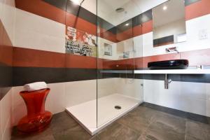 a bathroom with a glass shower and a red vase at Quaint Boutique Hotel Sannat in Sannat