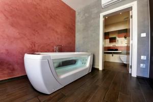 a bathroom with a bath tub and a sink at Quaint Boutique Hotel Sannat in Sannat