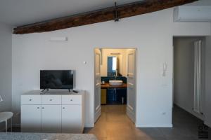 a living room with a television and a white wall at MONOLOCALE LE RONDINI centralissimo in Pesaro