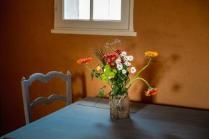 un jarrón lleno de flores sentado en una mesa en Suite campagnarde près Bordeaux, vue sur les vignes au Château Camponac, en Bourg-sur-Gironde