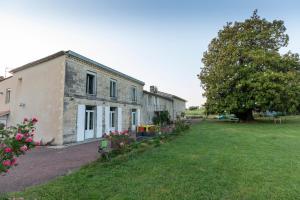 una antigua casa de piedra con un gran patio en Suite campagnarde près Bordeaux, vue sur les vignes au Château Camponac, en Bourg-sur-Gironde