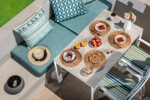 una mesa con platos de comida encima en Aether by Nymphs residence II, en Kokkinos Pirgos