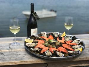 a plate of seafood with a bottle of wine and wine glasses at RÉVEIL SUCRÉ in Arzon