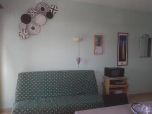 a living room with a couch and a tv at Location bord plage in Soulac-sur-Mer