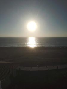 a sunrise over the ocean with the sun in the sky at Location bord plage in Soulac-sur-Mer
