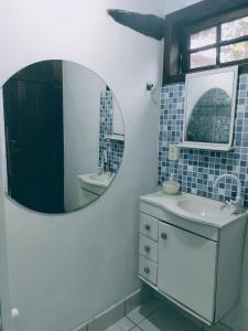 La salle de bains est pourvue d'un lavabo et d'un miroir. dans l'établissement Canto das Orquídeas, à Parati