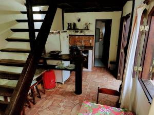 a small kitchen with a table and a refrigerator at Canto das Orquídeas in Paraty