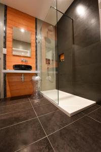 a bathroom with a glass shower and a sink at Quaint Boutique Hotel Sannat in Sannat