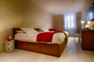a bedroom with a large bed with a red blanket at Quaint Boutique Hotel Sannat in Sannat