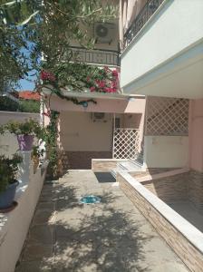 a walkway leading to a building with flowers on it at Filomeni Studios in Pefkohori