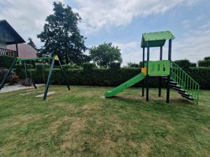 a playground with a slide in the grass at Zielona Przystań in Manasterz