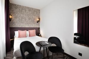 a hotel room with a bed with chairs and a table at Hôtel Prince Albert Gare de Lyon in Paris +64 photos