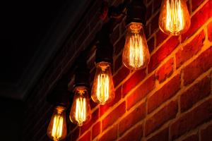 a group of lights hanging from a brick wall at Home Away From Home in Perea