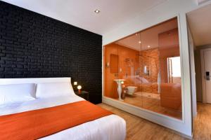 a bedroom with a brick wall and a bed and a bathroom at Quaint Boutique Hotel Sannat in Sannat