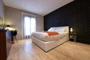 a bedroom with a white bed and a brick wall at Quaint Boutique Hotel Sannat in Sannat