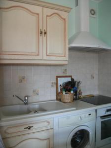 a kitchen with a sink and a washing machine at Location bord plage in Soulac-sur-Mer