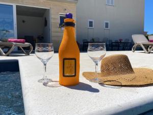 eine Flasche Champagner und zwei Gläser auf einem Tisch in der Unterkunft Apartment Maki with new Pool Nin in Vrsi
