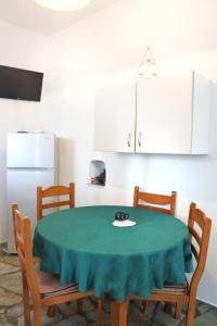 cocina con mesa, sillas y nevera en Fabrika's Breeze en Vári