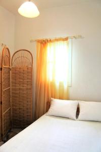 a bedroom with a white bed and a window at Fabrika's Breeze in Vari