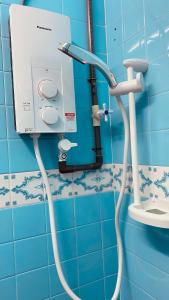 a bathroom with a hose hooked up to a sink at Angel Spa Garden's Homestay in Ipoh