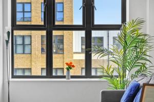 a window with a vase with an orange flower in it at Stunning, New & Stylish 1 Bed Apartment in Ramsgate