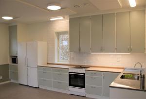 a kitchen with white appliances and white cabinets at Vårhaga Vandrarhem in Sjuntorp