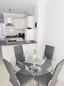 a dining room with a glass table and chairs at CANELA in Playa de San Juan