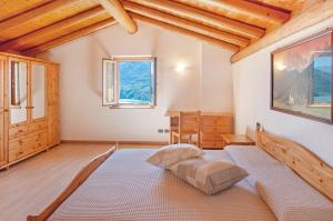 1 dormitorio con 1 cama en una habitación con techos de madera en Il ciliegio sul lago, en Verceia
