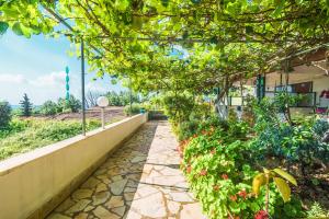 un sendero ajardinado con flores y un edificio en Family apartment, en Achílleion