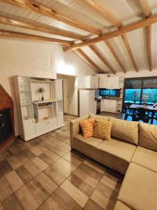 a living room with a couch and a kitchen at Casa Huellas de Malbec - Montaña y paz in Las Compuertas